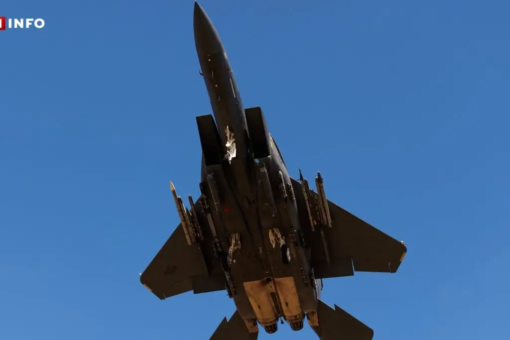 Avion de combat américain en vol, survolant un ciel bleu, avec silhouette sombre et ailes déployées