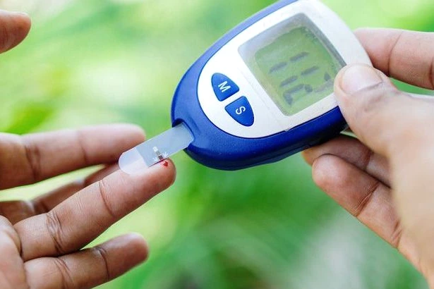 Dépistage du diabète à Guéret : une personne fait un test au doigt, soignant avec lecteur de glycémie.