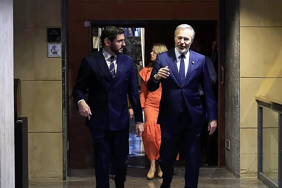 Dirigeants du PP et de Vox se serrant la main devant des drapeaux, lors d’un pacte en Aragon