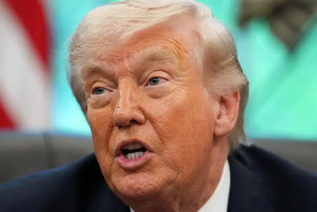 Donald Trump au pupitre, drapeaux américains derrière lui, lors d’une déclaration à la presse