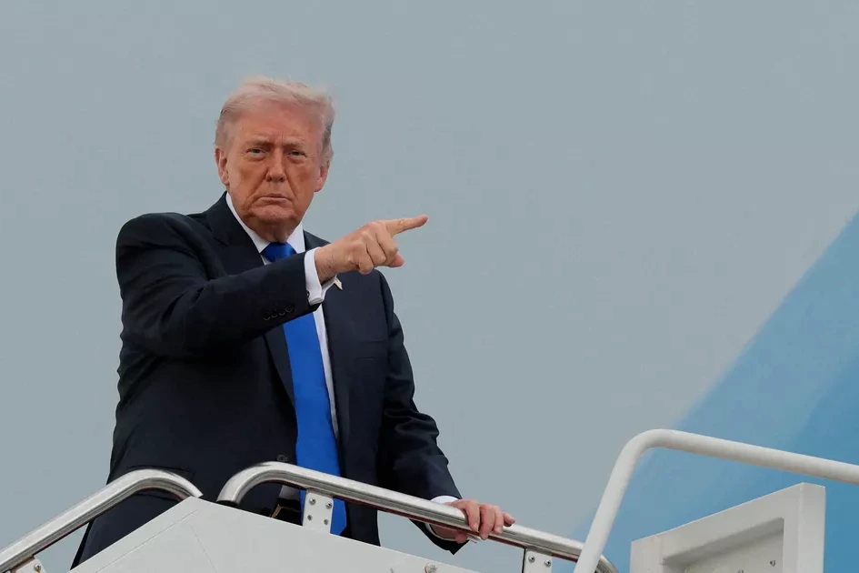 Donald Trump devant des drapeaux américains, parlant à la presse lors d’un événement officiel