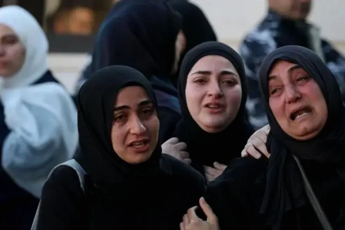 Drapeau du Liban flottant devant des bâtiments à Beyrouth, avec des drapeaux américains et iraniens en arrière-plan