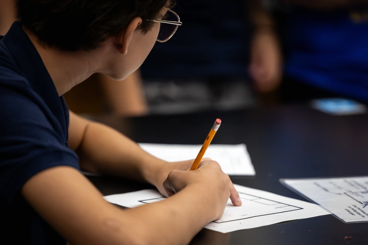 Drapeau du Texas flottant devant un bâtiment scolaire, avec des manuels d’études sociales sur un bureau