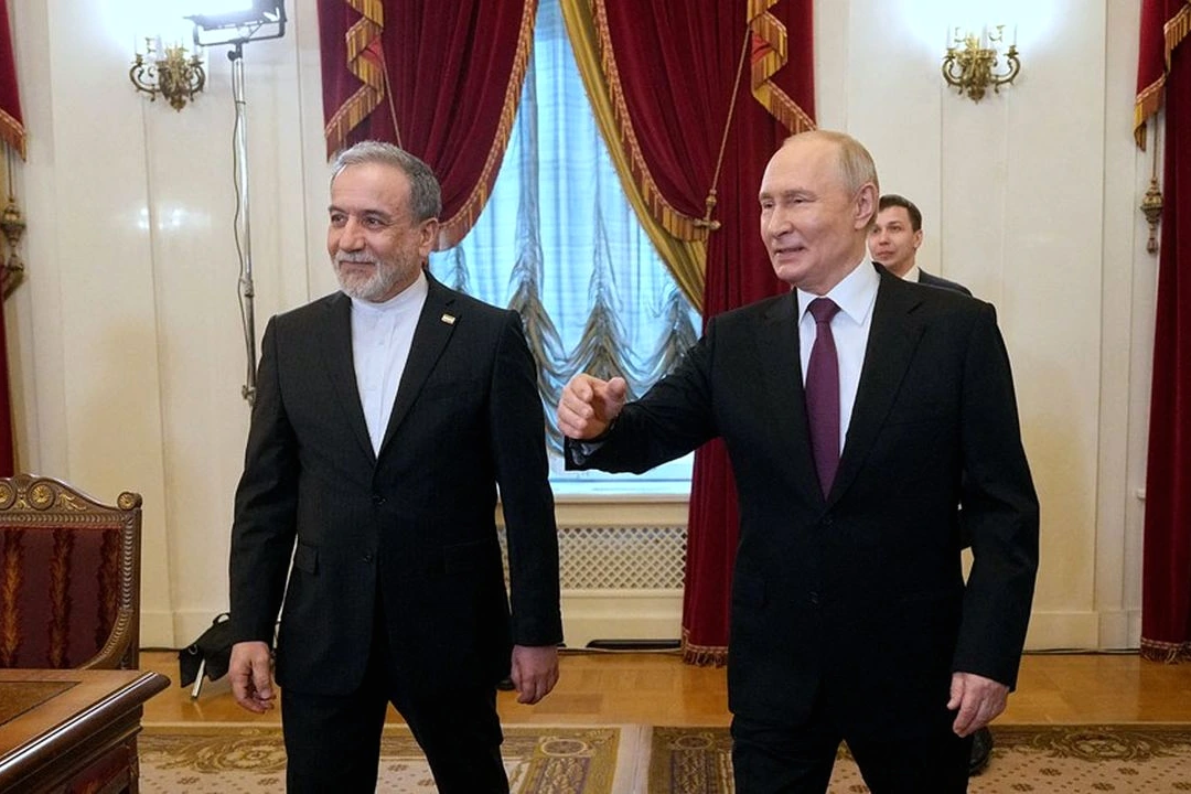 Drapeaux de l’Iran et de la Russie côte à côte devant un bâtiment officiel, en gros plan.