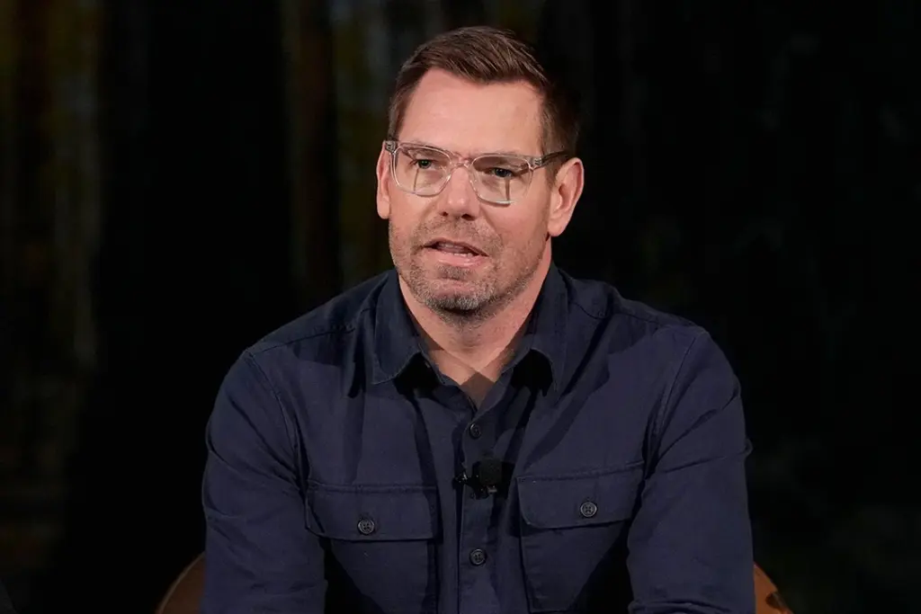 Eric Swalwell en costume devant le Capitole, entouré de journalistes et de micros lors d’une déclaration publique