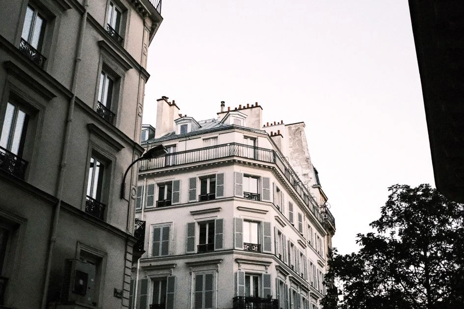Façade d’un immeuble à Paris avec panneau Airbnb, policiers et avis d’amende record affiché sur la porte