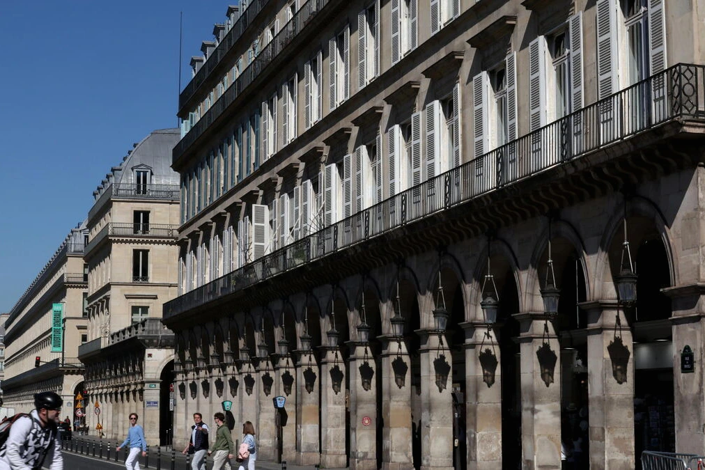 Façades haussmanniennes et vitrines le long de la rue de Rivoli à Paris, avec passants et circulation