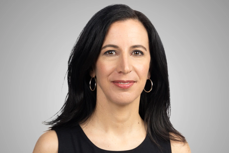 Femme victime de violence conjugale assise au sol, visage marqué, main levée pour se protéger