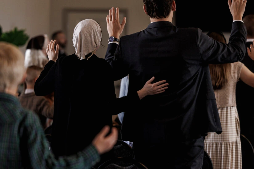 Femme votant dans un bureau de vote aux États-Unis, bulletin en main, sous l’affiche « vote familial »