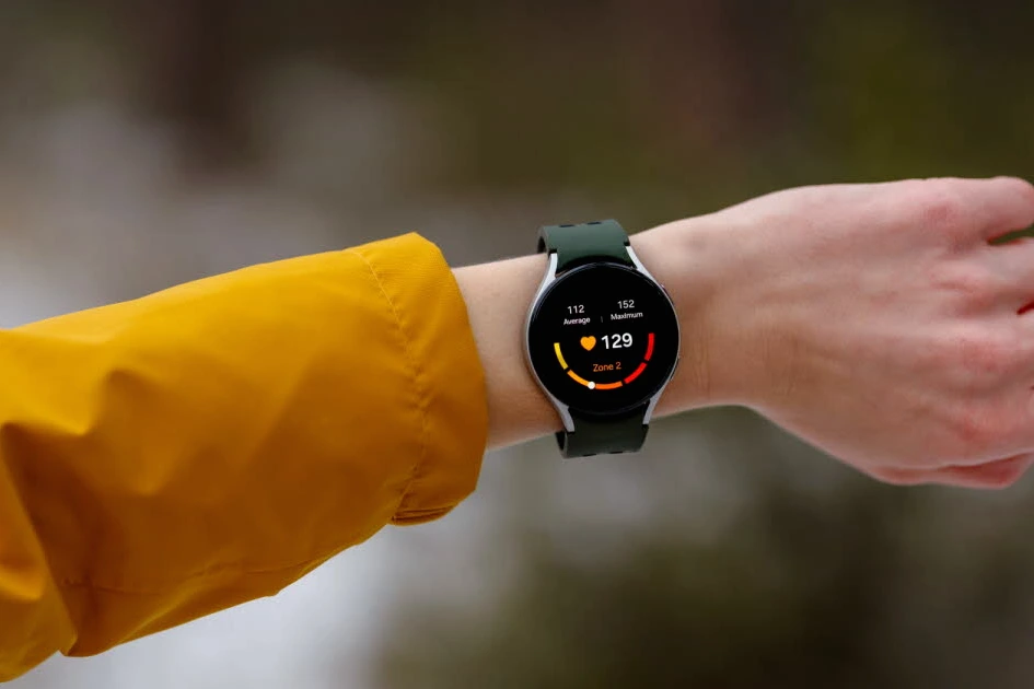 Gros plan d’une montre connectée au poignet affichant un tracé ECG et une alerte de rythme cardiaque irrégulier