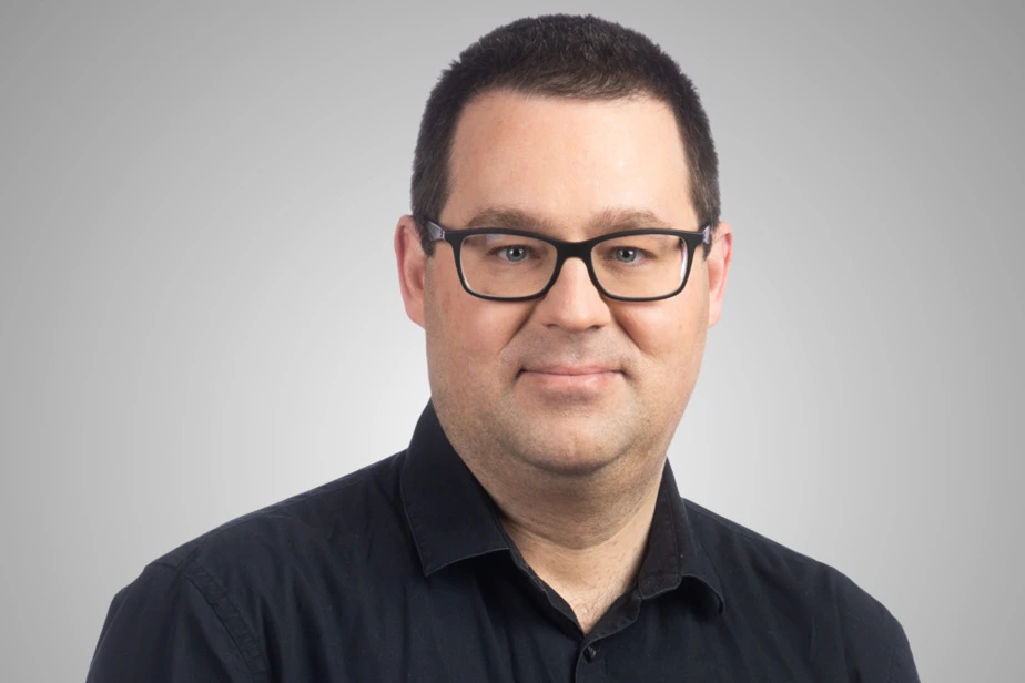 Huit ados assis en cercle dans une salle de classe, discutant avec des cahiers et un tableau derrière eux