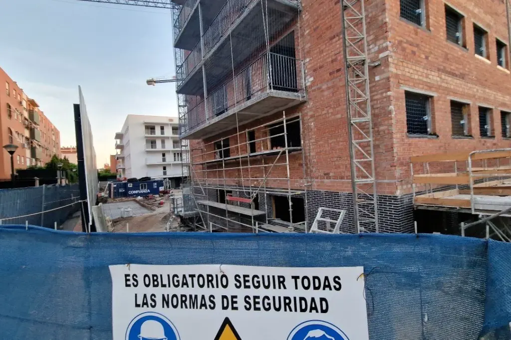 Jaime Palomera parlant devant un micro, en conférence, avec un écran de présentation en arrière-plan.