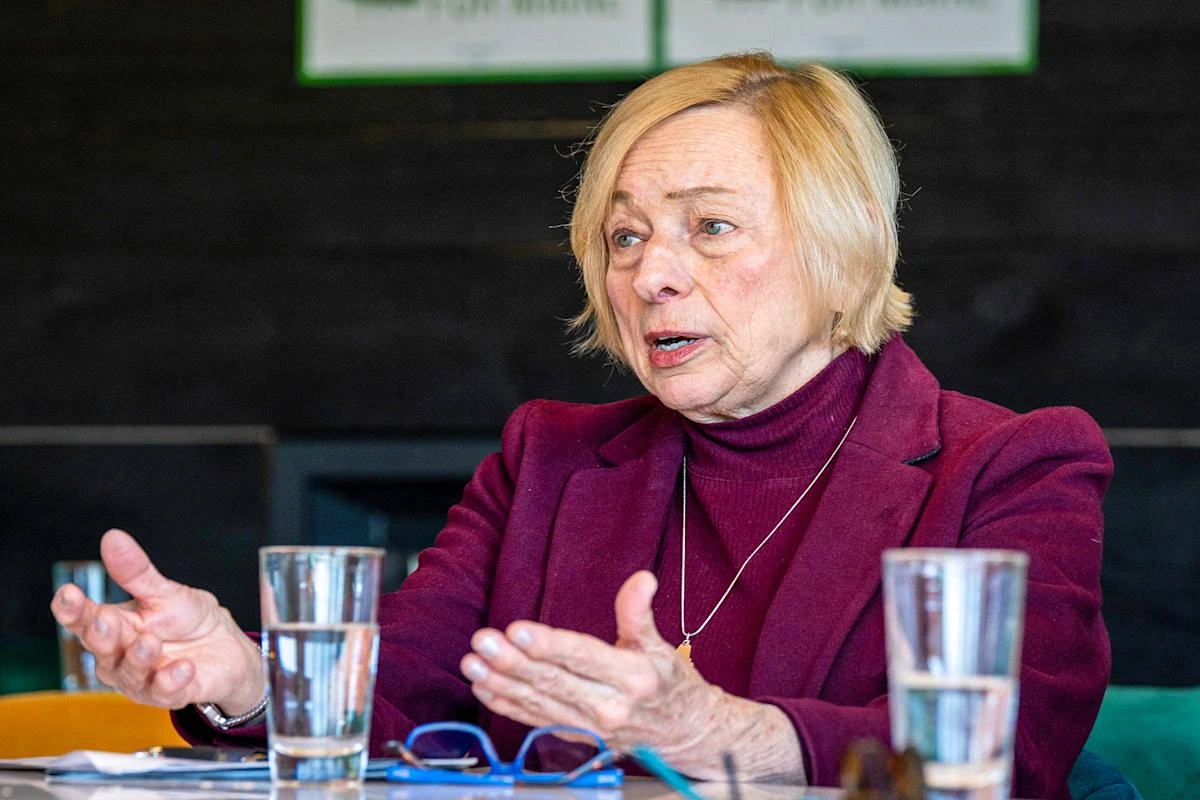 La gouverneure Janet Mills signant un document, devant des drapeaux, lors d’une conférence de presse au Maine