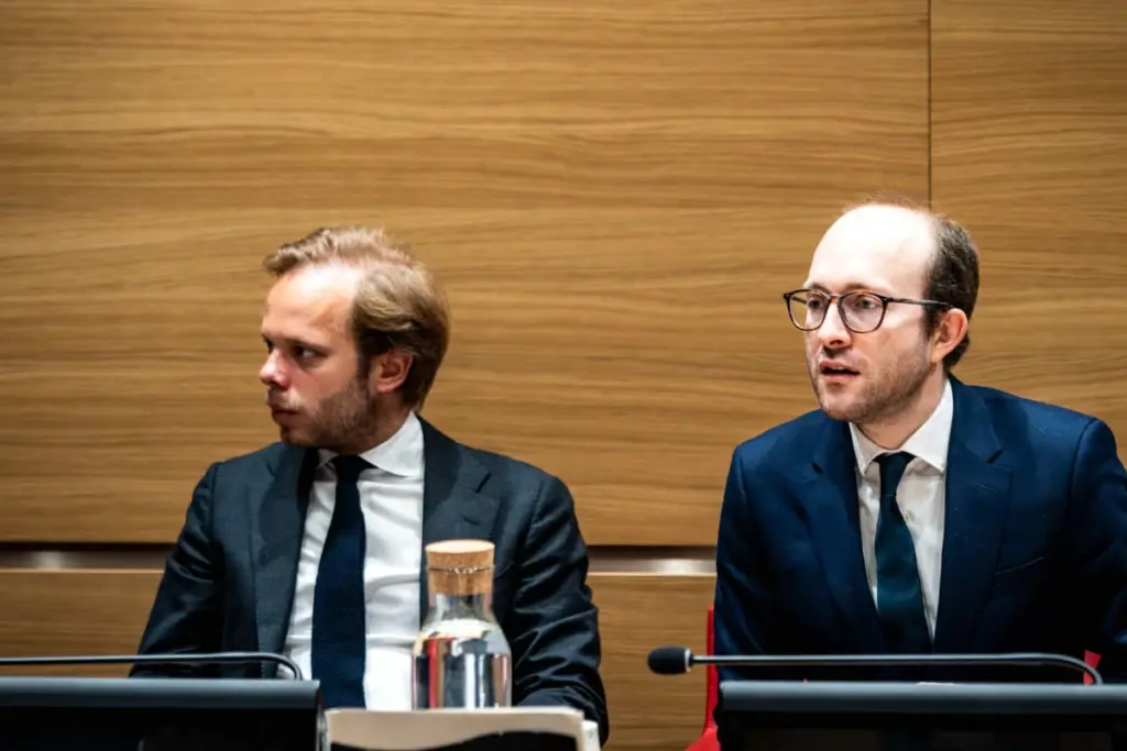 Le président de la commission sur l’audiovisuel public en costume, assis à une table lors d’une audition.
