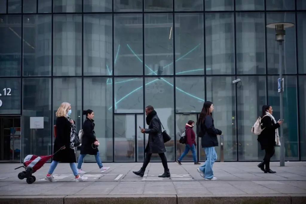 Lettre de motivation imprimée à côté d’un ordinateur affichant une interface d’IA, sur un bureau