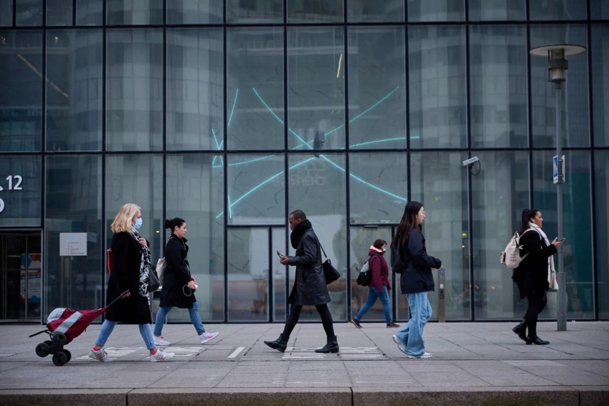 Lettre de motivation imprimée à côté d’un ordinateur affichant une interface d’IA, sur un bureau