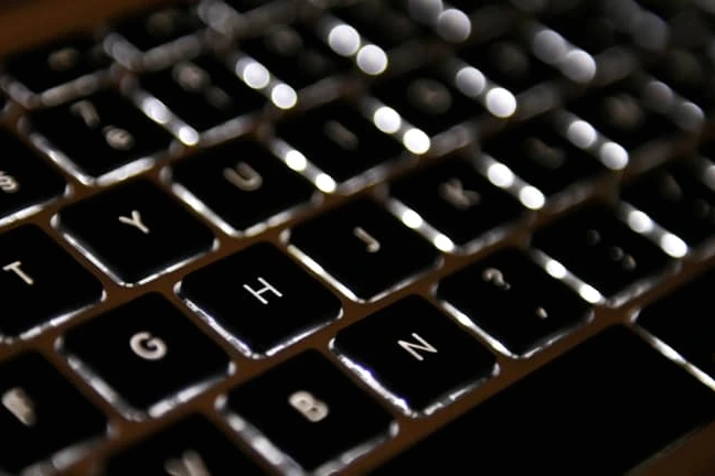 Logo de l’Agence nationale des titres sécurisés sur un écran, avec un cadenas et du code en arrière-plan