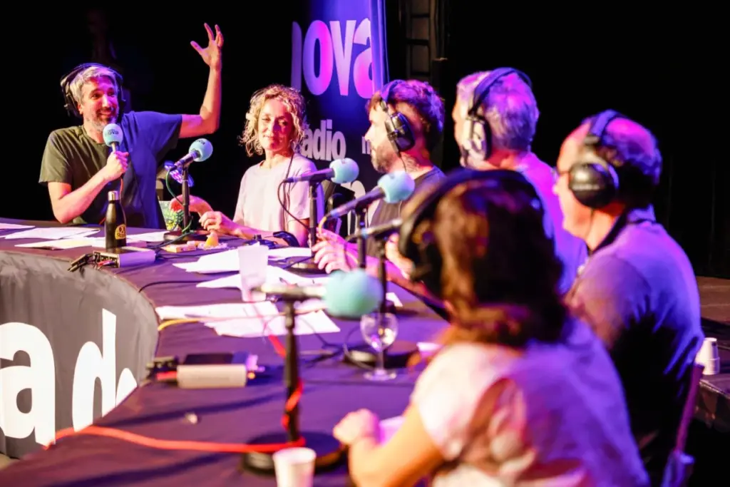 Micro de studio radio avec logo France Inter au premier plan, consoles et casque en arrière-plan