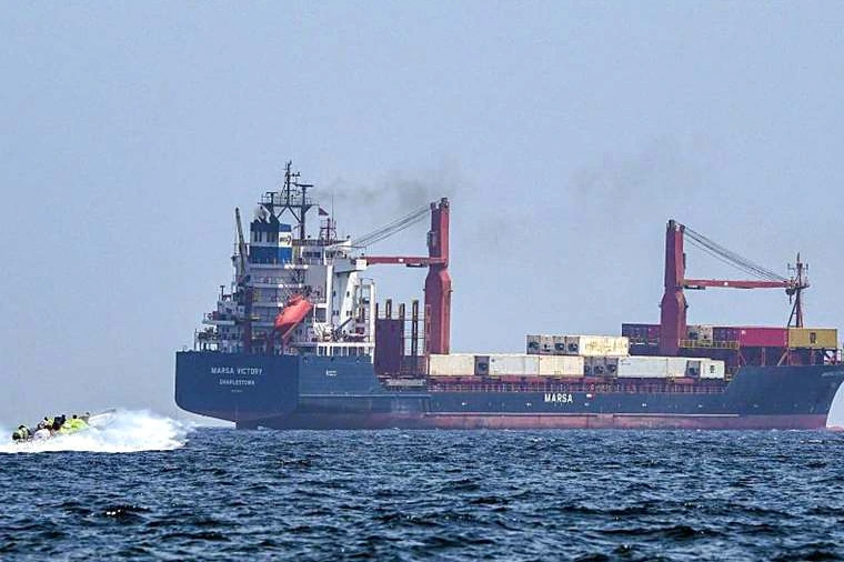 Navires traversant le détroit d’Ormuz, avec un drapeau iranien flottant au premier plan