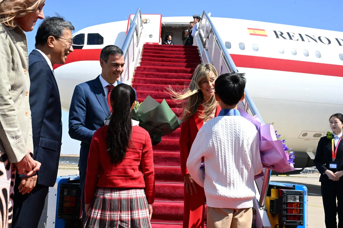 Pedro Sánchez et Begoña Gómez marchent devant un site historique en Chine, entourés de visiteurs.