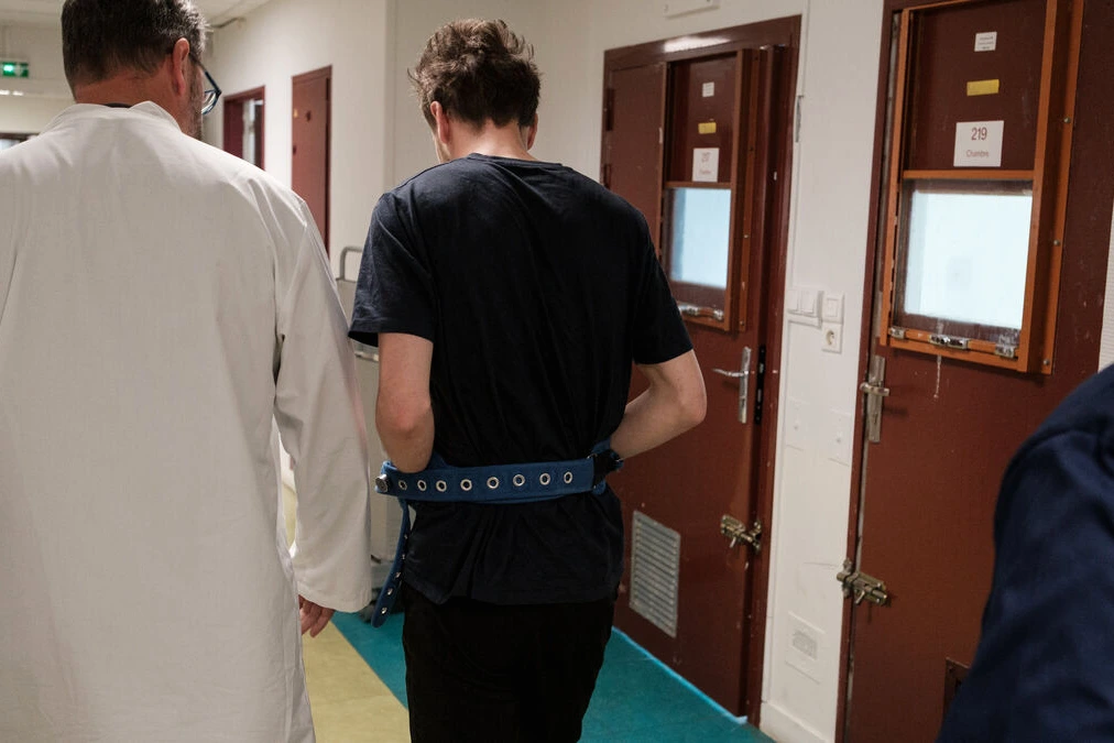 Policiers à Paris devant un commissariat, escortant une personne vers les urgences psychiatriques.