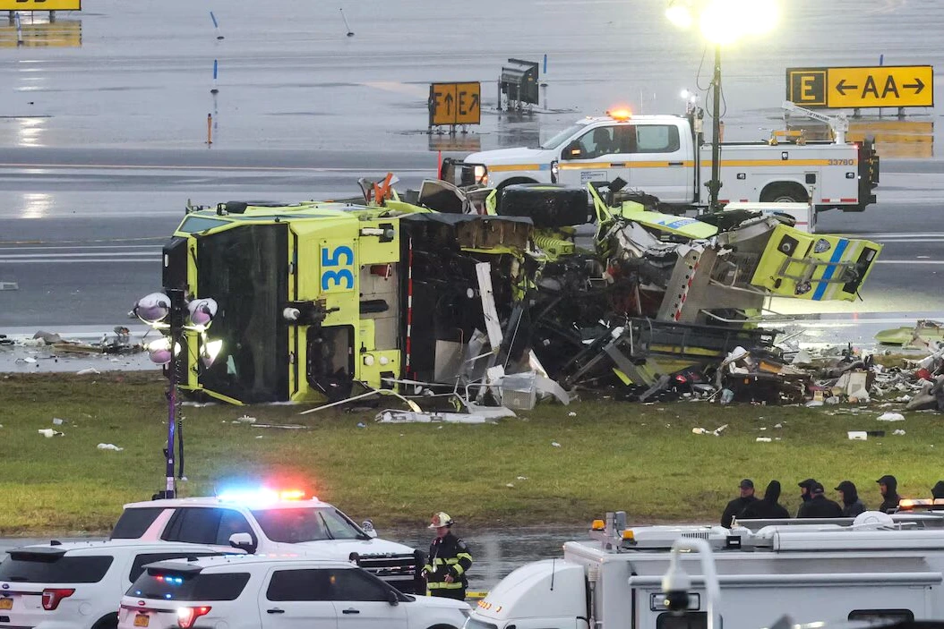 Pompier sur le tarmac de l’aéroport LaGuardia près d’un avion, véhicules d’urgence en arrière-plan