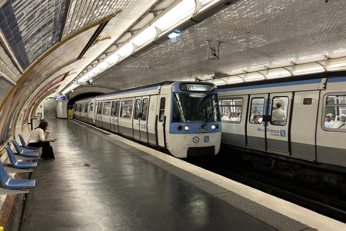 Quai de la ligne 7 du métro RATP, panneaux d’information et voyageurs attendant pendant l’arrêt