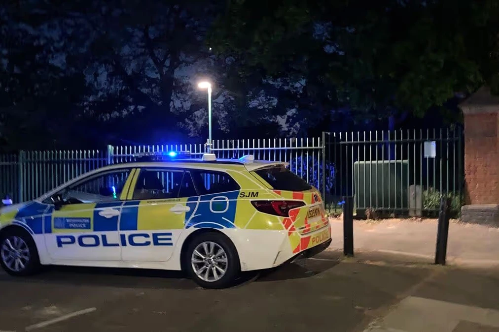 Scène de parc à Londres avec ruban de police près d’un banc, où une femme et un enfant sont morts
