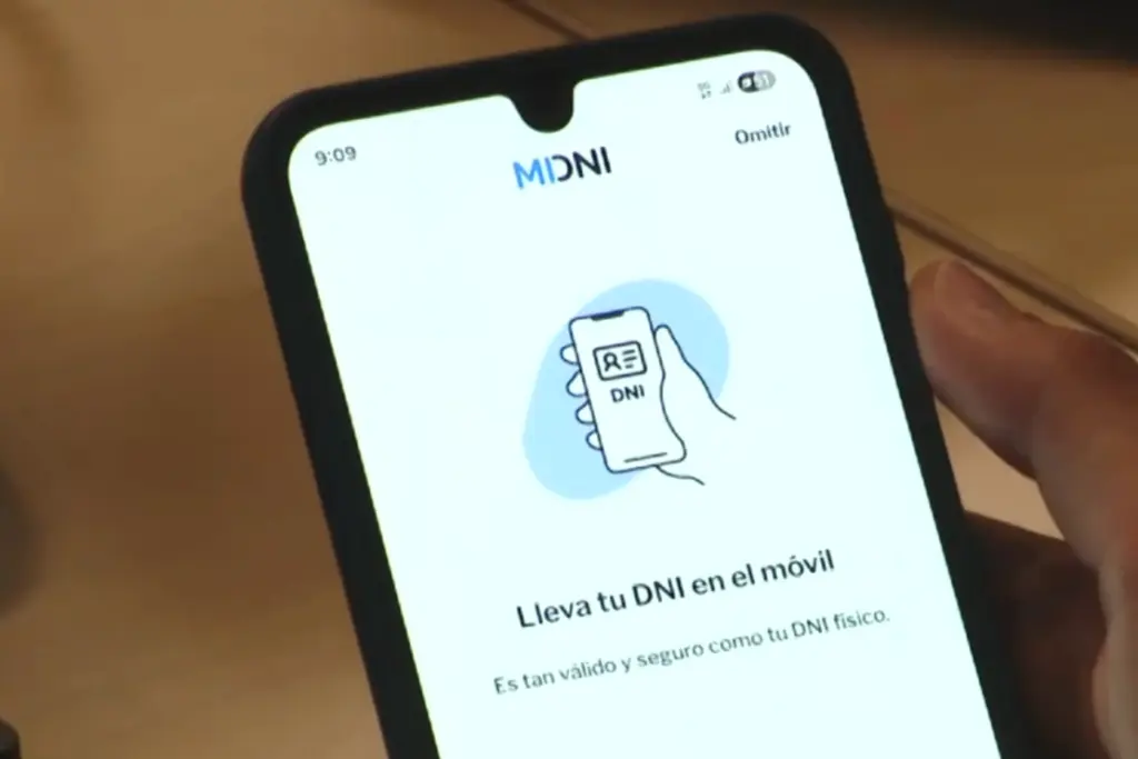 Smartphone affichant un DNI numérique sur l’écran, tenu en main devant un fond neutre