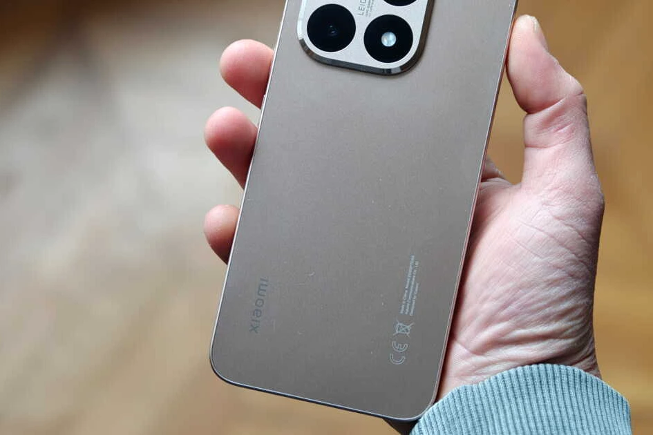 Smartphone Xiaomi 15T tenu en main, écran allumé affichant l’interface, sur fond de bureau lumineux.