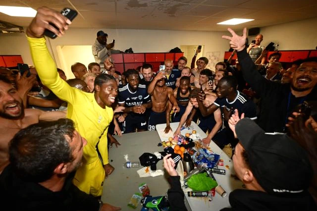 Téléphones portables sur un banc, sportifs en tenue discutant à l’arrière-plan dans un gymnase