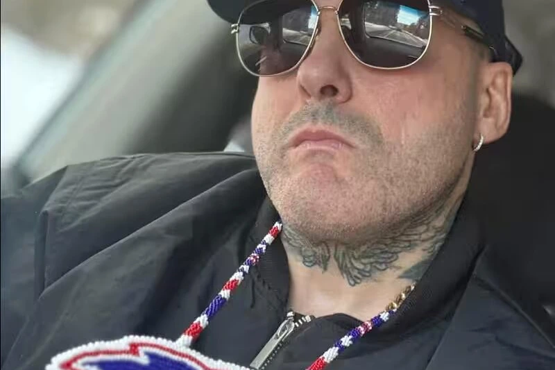 Trafiquant de drogue menotté escorté par des policiers devant un tribunal, visage flouté, au premier plan