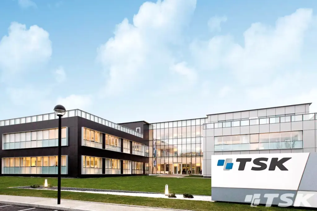 TSK devant un écran boursier, graphiques et cours en hausse, entouré de documents financiers et d’un logo banque