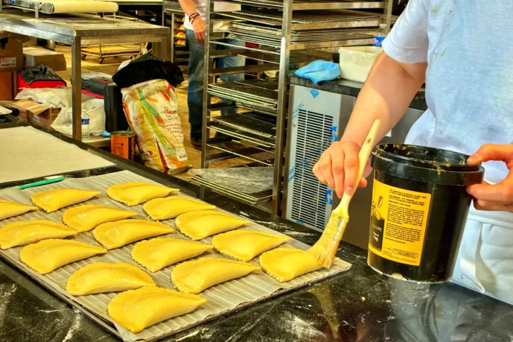 Boulanger pétrissant une pâte sur un stand de la Fête du Pain, devant Notre-Dame de Paris sur le parvis