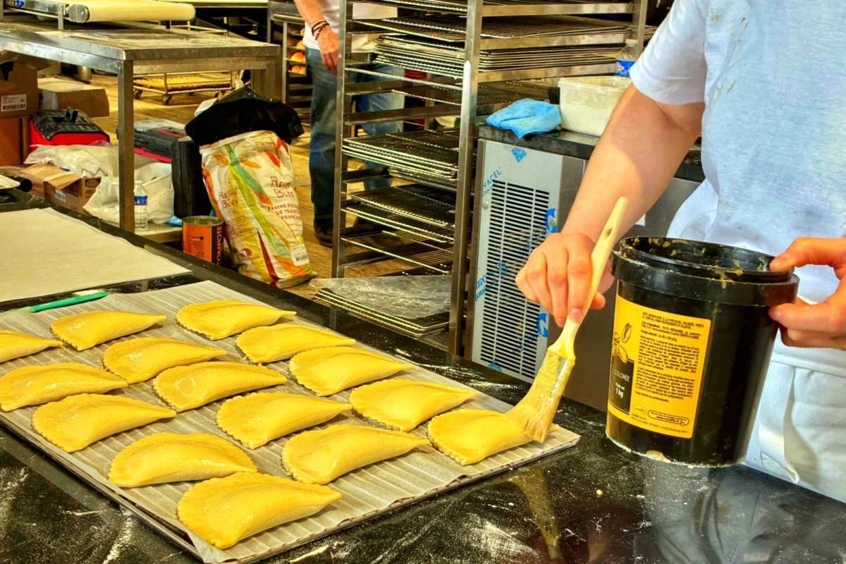 Boulanger pétrissant une pâte sur un stand de la Fête du Pain, devant Notre-Dame de Paris sur le parvis