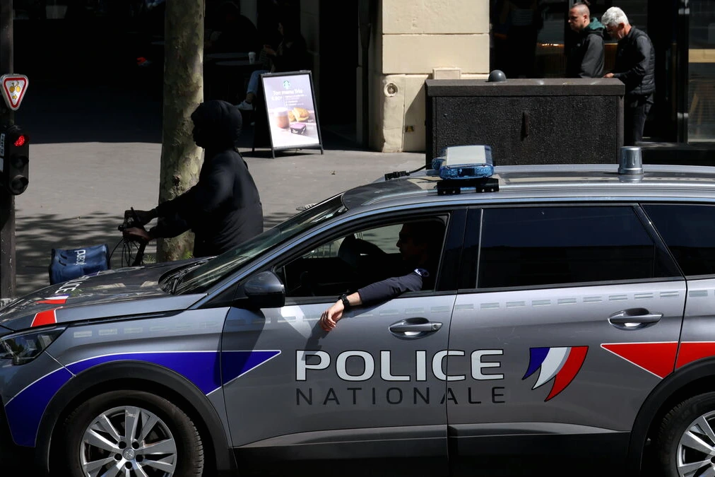 Boutique de luxe à Paris avec vitrine brisée et voiture-bélier encastrée, débris sur le trottoir