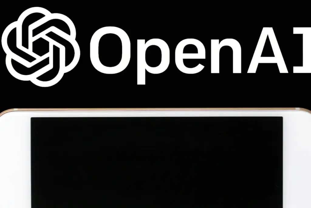 Chercheurs devant un tableau rempli d’équations, utilisant l’IA d’OpenAI sur un ordinateur portable.