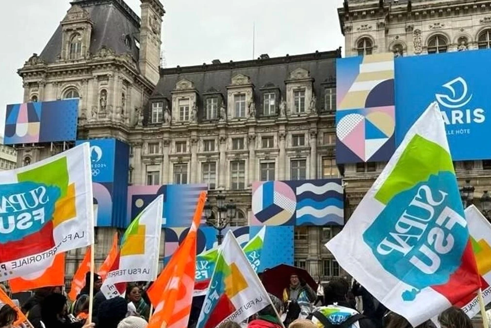 Grève périscolaire à Paris : parents et enfants devant une école, portail fermé et affiche de grève