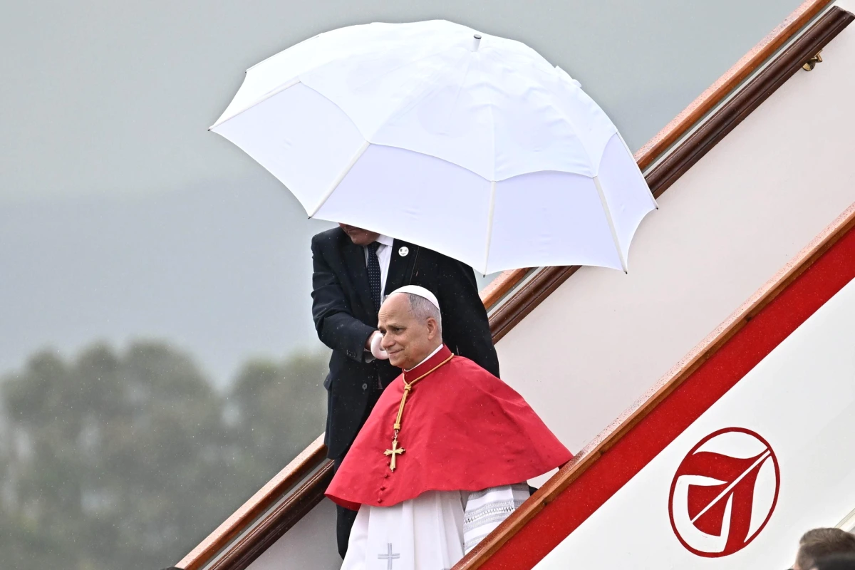 Le pape Léon XIV salue la foule depuis un balcon, vêtu de blanc, avec la basilique en arrière-plan