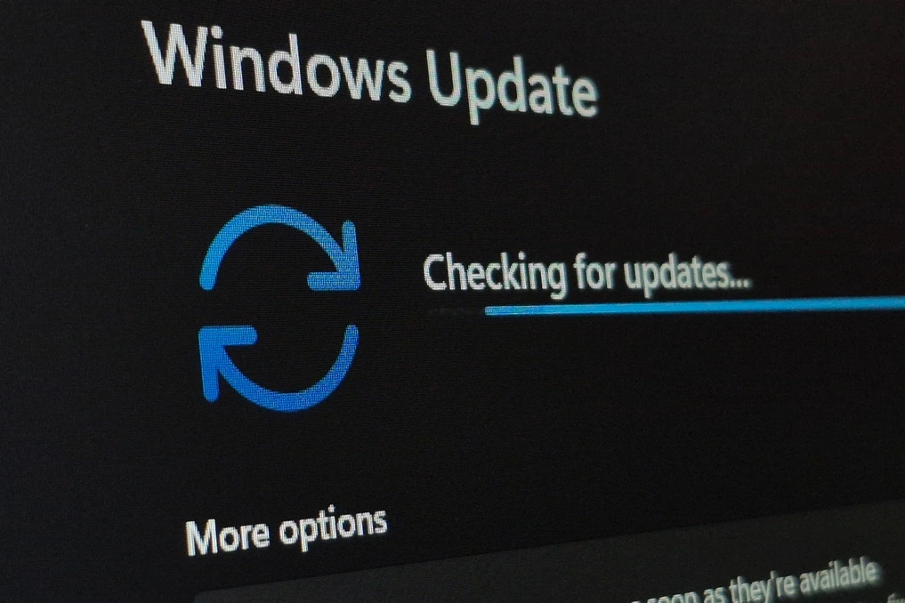 Logo Microsoft sur un écran, avec Windows 11 affiché et une icône d’alerte liée aux mises à jour de sécurité