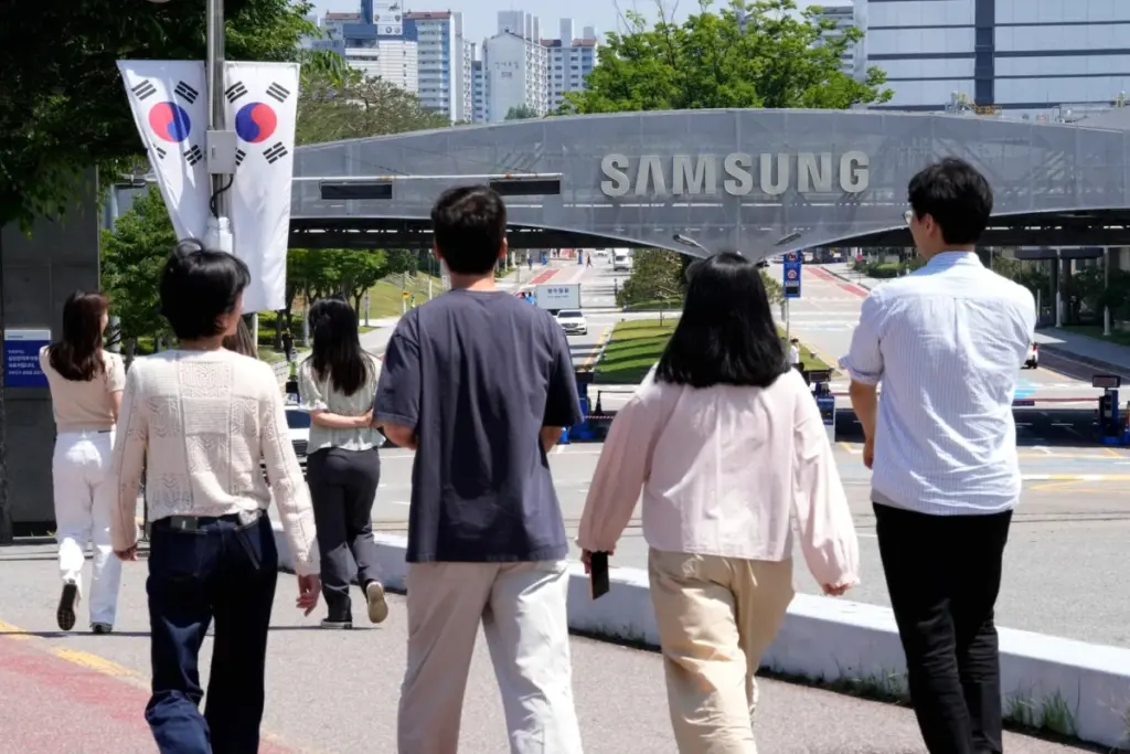Logo Samsung sur la façade d’un immeuble en Corée du Sud, avec employés entrant dans le bâtiment