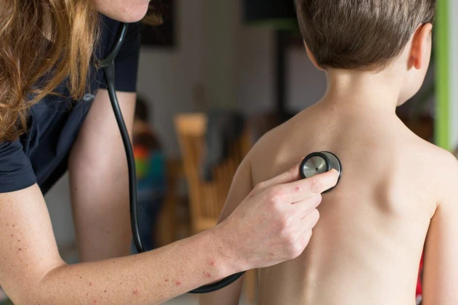 Médecin généraliste en consultation, accueillant un nouveau patient dans un cabinet médical lumineux