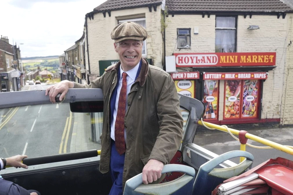Nigel Farage en costume, micro en main, s’adresse à la foule lors d’un meeting électoral au Royaume-Uni