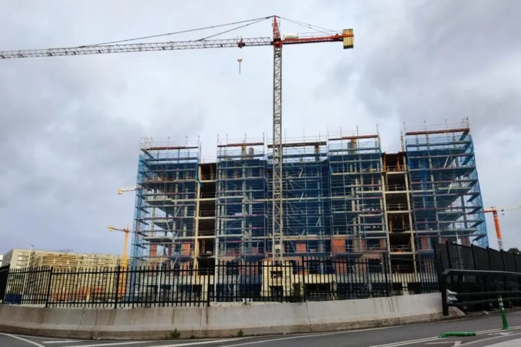 Panneau « À vendre » devant un immeuble résidentiel en Galice, avec façades d’appartements en arrière-plan