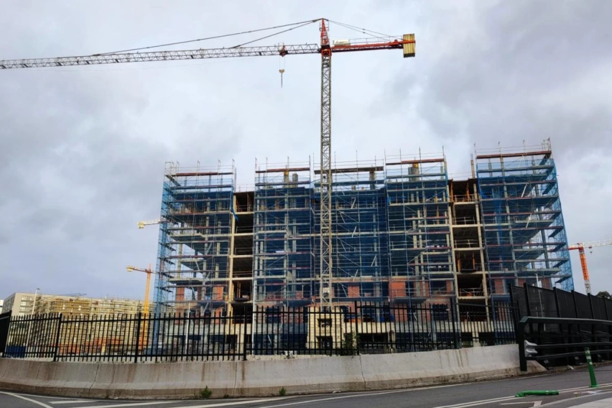 Panneau « À vendre » devant un immeuble résidentiel en Galice, avec façades d’appartements en arrière-plan