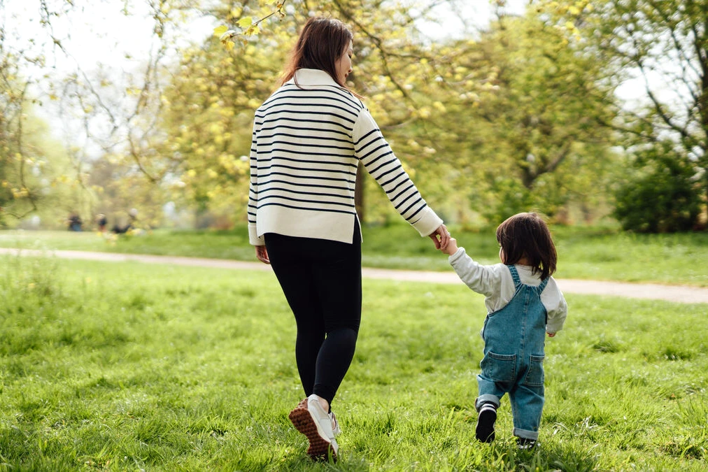 Parents séparés à Paris, chacun avec un enfant, se croisent sur un trottoir près d’un immeuble haussmannien
