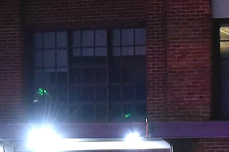 Propriétaire d’une boîte de nuit de Montréal debout devant l’entrée fermée, enseigne lumineuse en arrière-plan