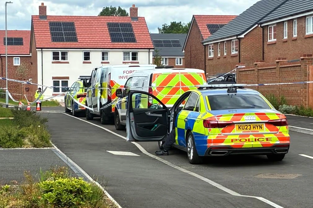 Ruban de police à Burntwood devant une rue résidentielle, après la mort d’un homme et d’un chien poignardé