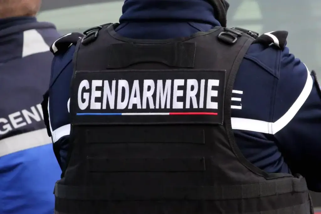 Ruban de police devant une maison, policiers sur place après le meurtre présumé par un policier de son ex-femme et leurs enfants