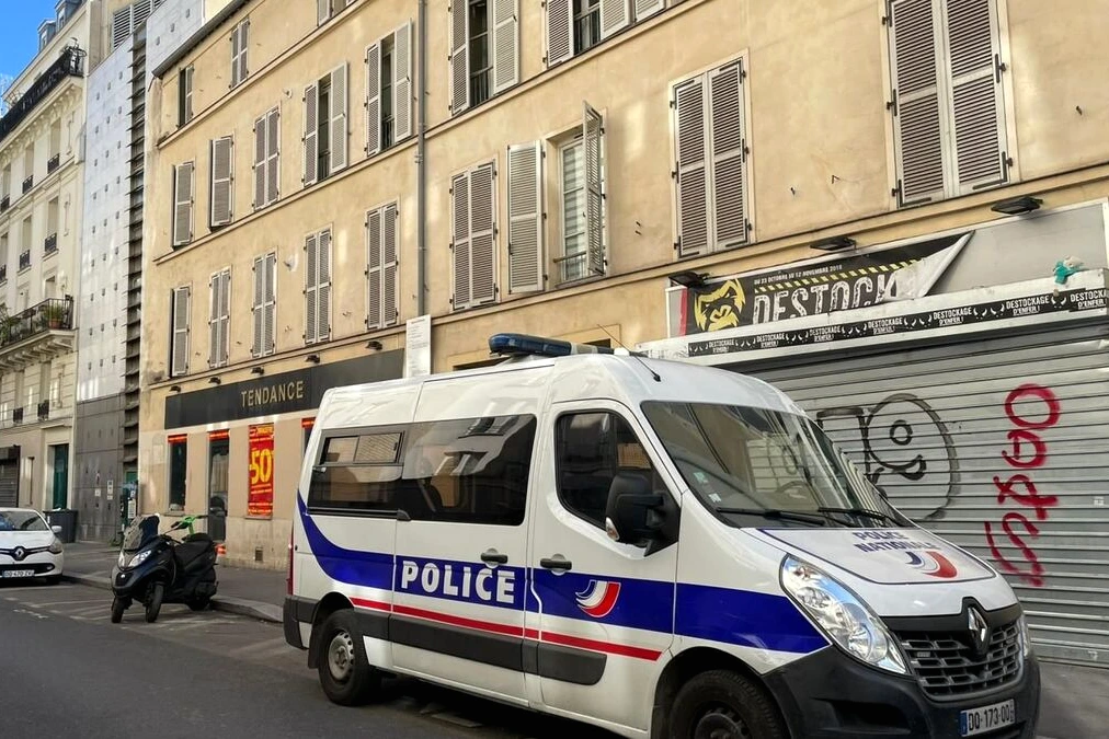 Ruban de police et gyrophares devant un immeuble à Paris, après l’arrestation d’un ado soupçonné.